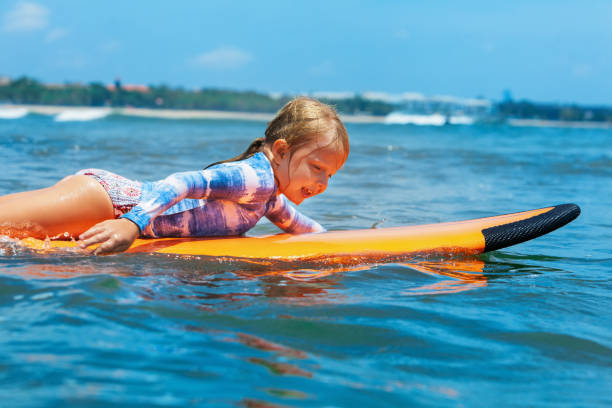 istock Young surfer paddle on surfboard with fun on sea waves 1066070030