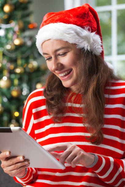 istock Young woman using digital tablet on Christmas night 1066086406