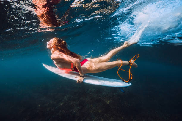 istock Surfer with surf board dive underwater with under big ocean wave 1066088376