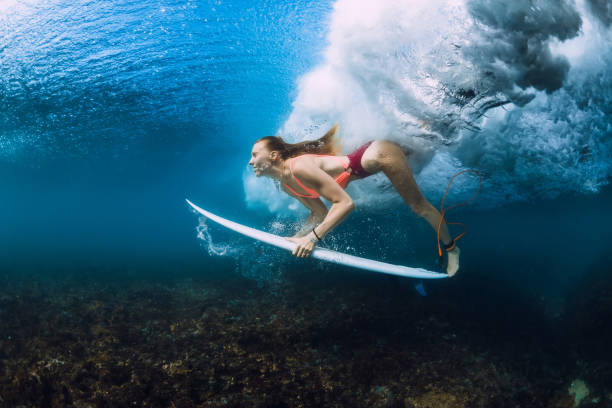 istock Attractive surfer woman dive underwater with under barrel wave. 1066088388