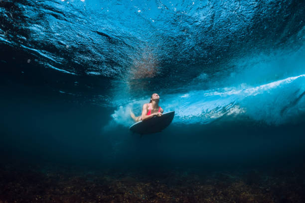 istock Surfer woman in bikini with surfboard dive underwater with under barrel ocean wave 1066088478