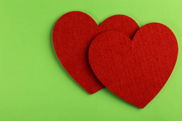 istock Two red felt heart on bright green background. St. Valentine's day 1066100666