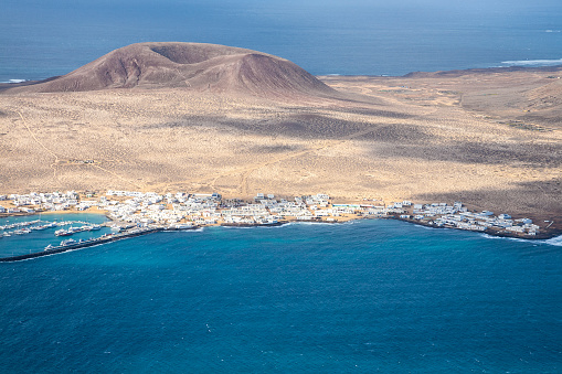 A view on the village and the volcano crater on the La Graciosa island near the north of Lanzarote, Canary Islands, Spain
