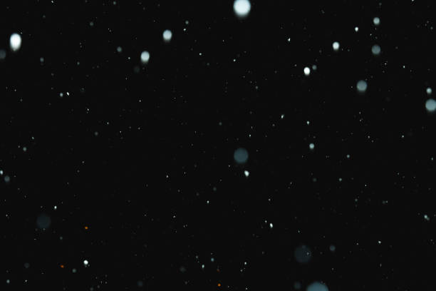 istock Flakes of snow falling on a black background. Isolated 1066114962
