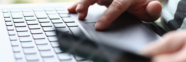 istock Male arms hold credit card press buttons 1066126200