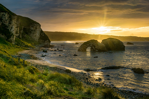 This is a picture of the sea arch at Ballintoy on the Antrim Coast in Northern Ireland Taken at sunset.
