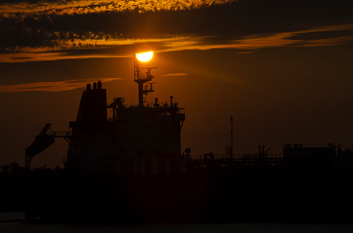 Cargo Ship Sailing at Sunset