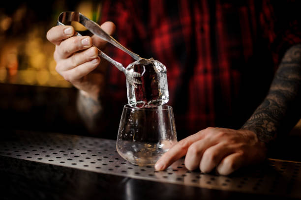 istock Bartender hand putting a big ice cube into a whiskey dof 1066135658