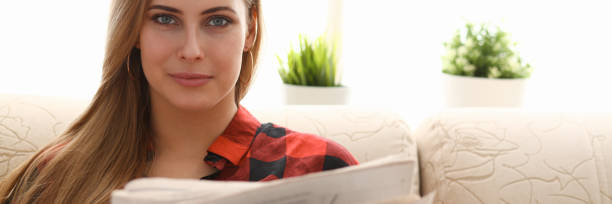 istock woman drinking coffe and reading sit on sofa 1066136022