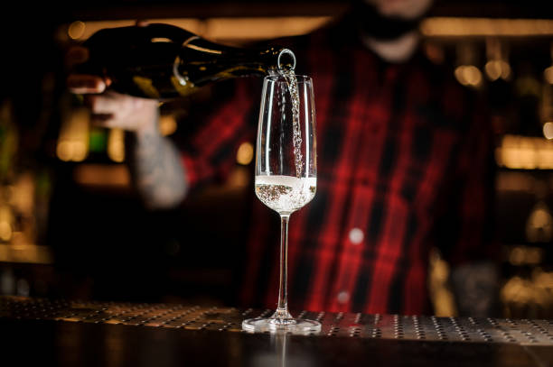 istock Barman pouring sparkling wine, into an elegant glass 1066136432