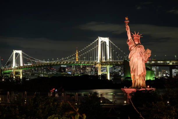 tokyo, japon - 1er novembre 2018-the odaiba statue de la liberté surplombe le pont de l’arc-en-ciel et la baie de tokyo dans la soirée. - réplique de la statue de la liberté odaiba photos et images de collection