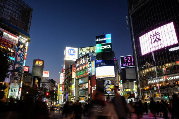 人々 は、夜の東京の小売と見事なデジタル看板の下でエンターテイメント地区渋谷の交差点で歩きます。 - shibuya 109 ストックフォトと画像