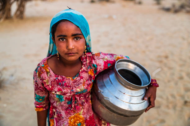 ragazza indiana che trasporta acqua da pozzo, villaggio desertico, india - povertà asia foto e immagini stock