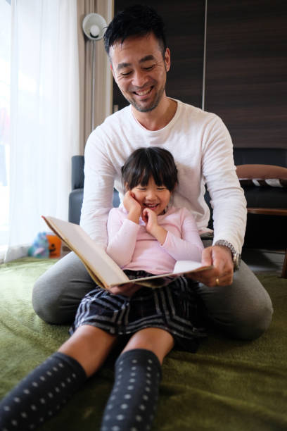 istock Father reading book with daughter at home 1066160446