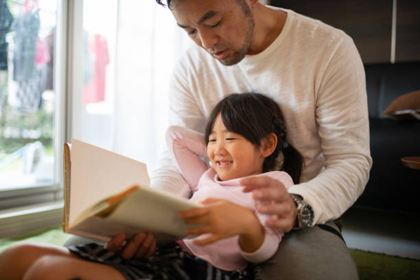 istock Father reading book with daughter at home 1066160620