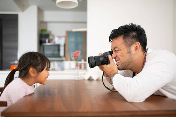 Father taking photo of daughter at home Everyday life of father and daughter at home digital single lens reflex camera photos stock pictures, royalty-free photos & images