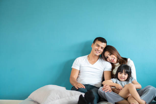 ritratto felice famiglia asiatica su sfondo blu - asian ethnicity baby mother family foto e immagini stock