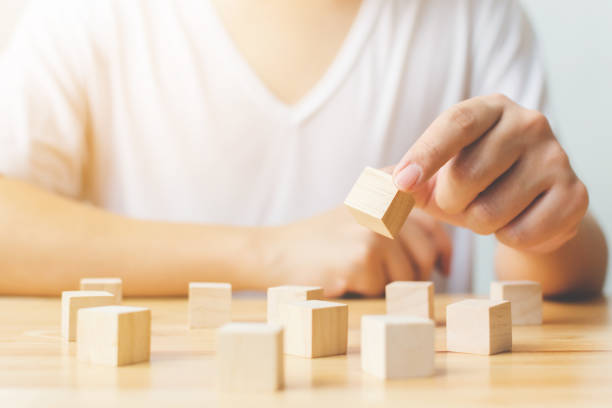 istock Brain therapy rehabilitation cognitive psychological testing. Hand holding wood block cube therapy equipment 1066165534