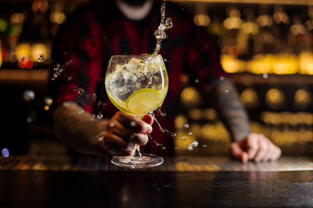 istock Bartender making splash of a delicious Gin Tonic cocktail with lime slices 1066169180