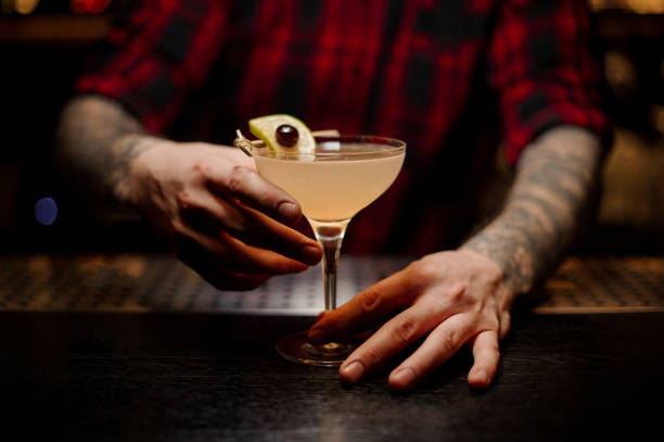 istock Bartender serving a Daiquiri cocktail decorated with lime and berry 1066169204