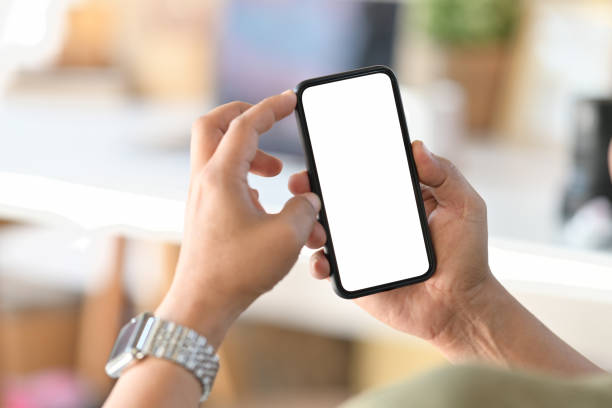 istock Male hand holding blank screen mobile phone in office. 1066173876