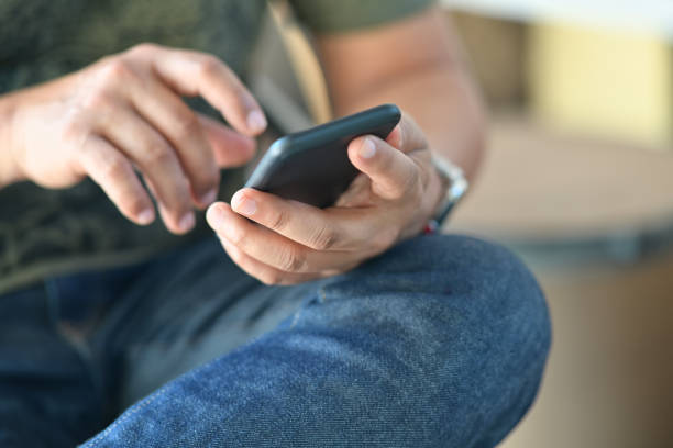 istock Cropped shot of male hand using mobile phone. 1066174032