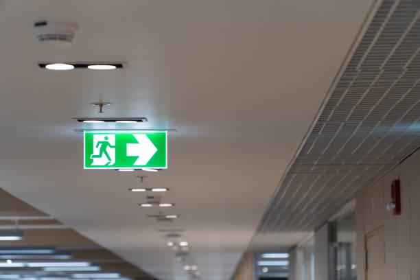 istock Green fire escape sign hang on the ceiling in the office. 1066176358