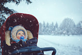 Little boy in stroller in winter park