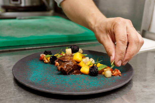 istock Chef is decorating stewed veal cheeks with herbs and berries 1066189540