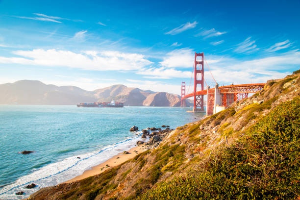 golden gate bridge with cargo ship at sunset, san francisco, california, usa - golden gate bridge panoramic california scenics imagens e fotografias de stock