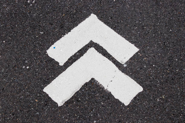 istock White painting in forward direction arrow symbol on black asphalt road background 1066200328