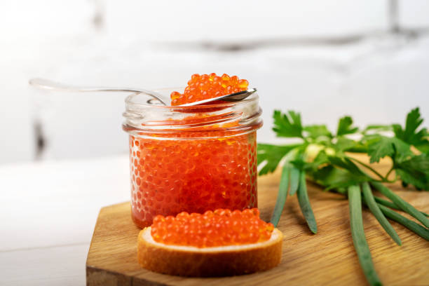 istock caviar appetizer - jar with red fish roe and herbs on the table 1066200450