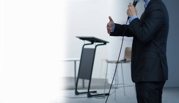 istock Presenter on Stage with Blank Copy Space for Text. Lecture Speaker at Podium at Business Education Conference Hall. Technology Training Seminar Presentation Event. 1066203792
