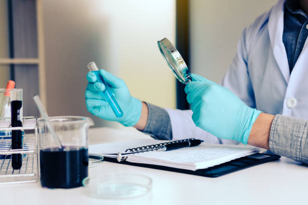 istock Chemist or scientist using magnifying glass dispense the solution in a glass jar. 1066206052