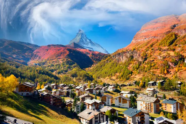 Autumn resort slopes and bright beautiful landscape with the famous Matterhorn peak in autumn in Switzerland. Original beautiful houses of the Swiss highlanders on a moonlit night