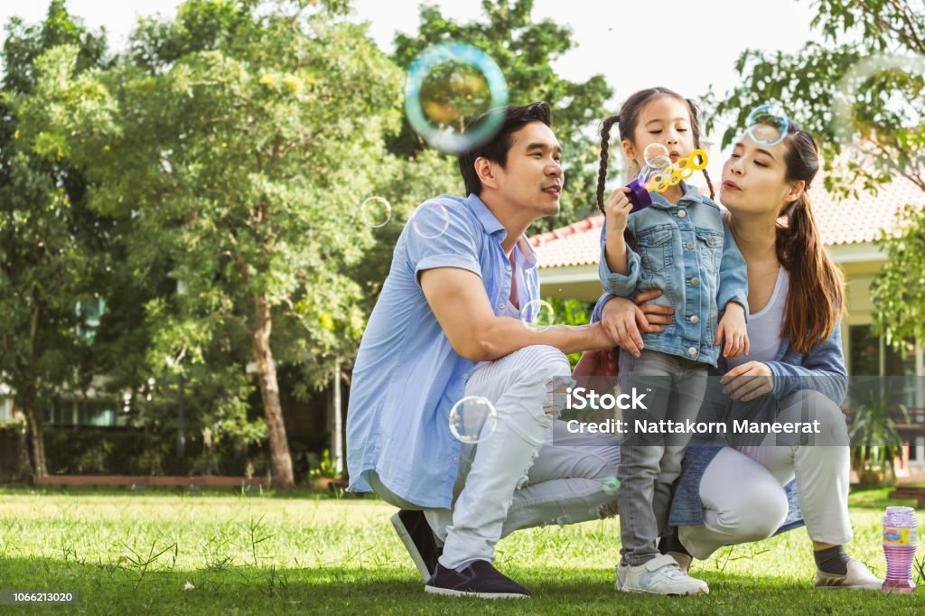 Família asiática feliz jogando no sorriso e jardim bolha sopro, feliz - Foto de stock de Família royalty-free