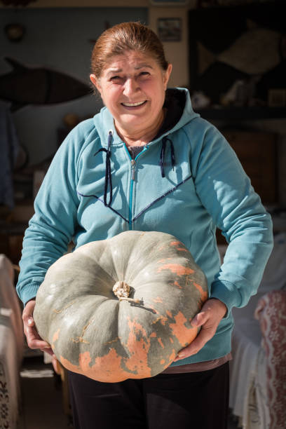 istock Woman Holding a Pumpkin Smiling 1066219846