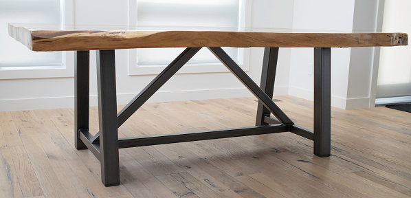 Studio shot of hand made table made of Monkey Pod Tree wood with steal metal bracing and legs.