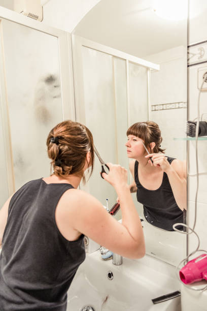 istock woman is cutting her hair 1066227256