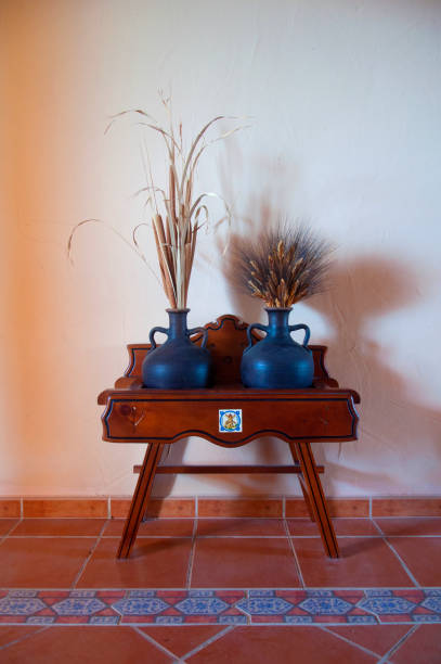 Two black jars with dry weat on the small table, decoration, front view