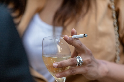 Close-up of woman drinking and smoking