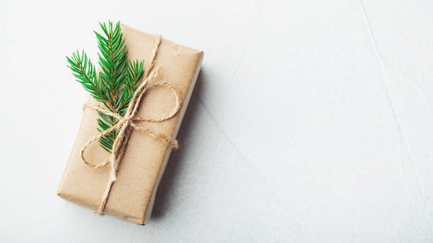 istock Christmas composition. Christmas gift, pine cones, fir branches on stone white background. Flat lay, top view, copy space 1066241892