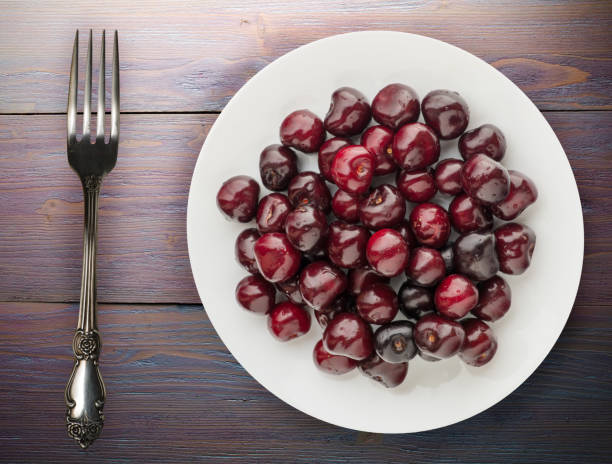 berry cherry on a plate on a wooden background. fruit diet. vegan food