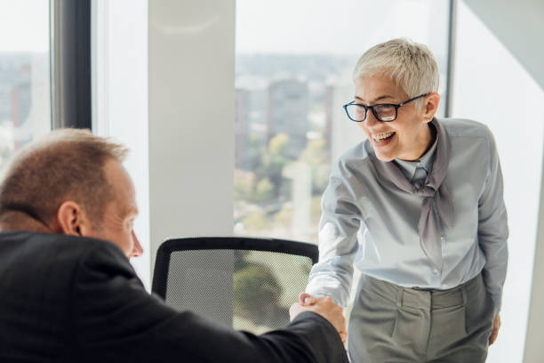 istock Smiling woman shaking hands with a coworker 1066252296
