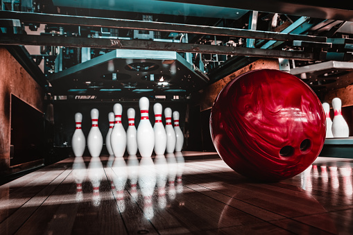 A close-up of a young, attractive female holding a bowling ball in one hand