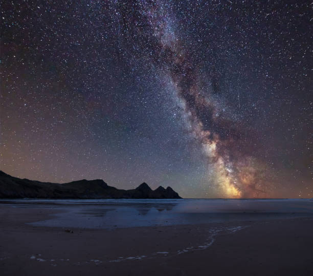 istock Vibrant Milky Way composite image over landscape of yellow sandy beach Three Cliffs bay 1066257774