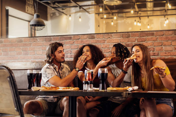 istock Crazy young friends enjoying eating pizza 1066259126