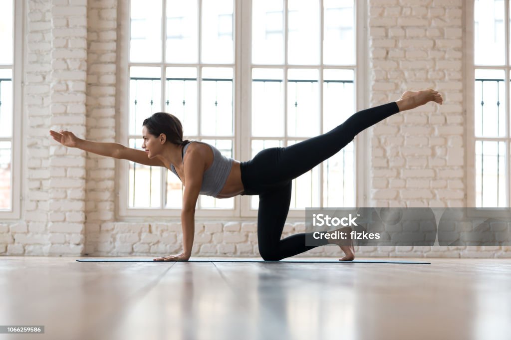 Deportiva atractivo joven practicando yoga, hacer ejercicio de patada de burro - Foto de stock de Pilates libre de derechos