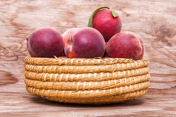 Peach isolated on wooden background.
