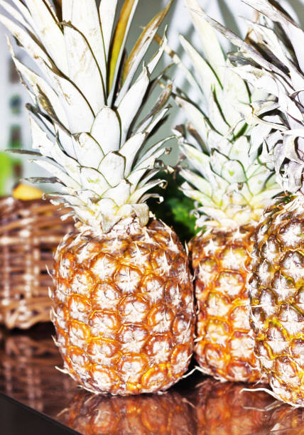 istock fresh pineapples on counter top with out of focus fruit basket 1066264288
